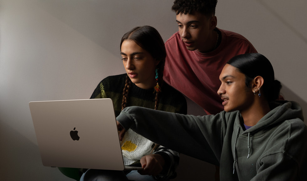 세 사람이 MacBook Air 15를 살펴보는 모습.